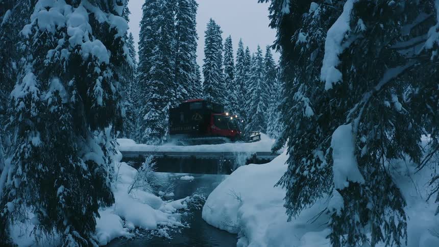 Red and black vehicle removing snow from the road