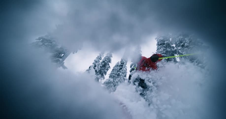 A person skis down a steep hill covered in very thick snow