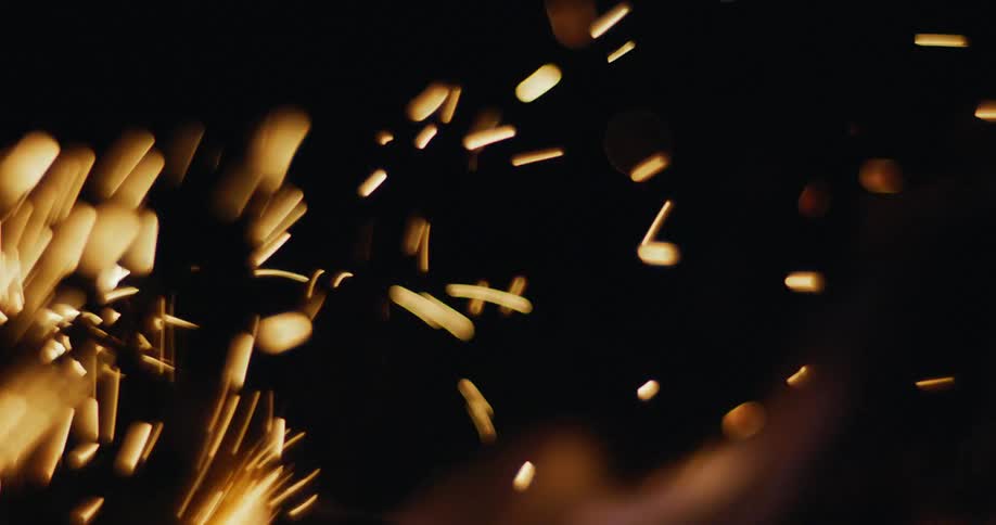 Numerous sparks are released into the air from a burning fire