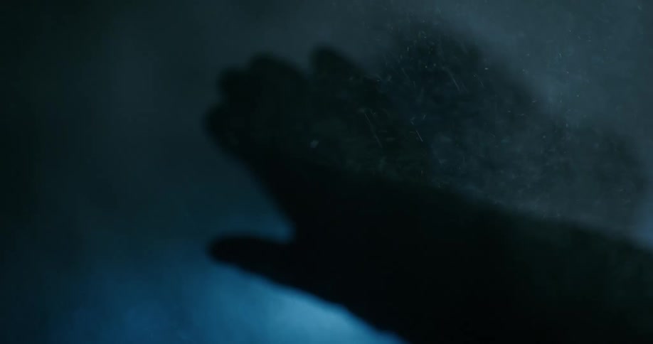 Close up view of a person walking outdoors at night while its snowing