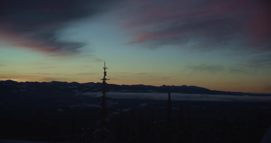The sky is barely illuminated by the sun which is behind a mountain range