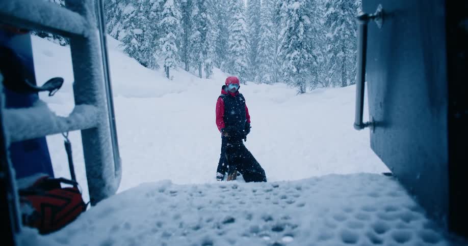 A man and a dog stand as snow falls on them