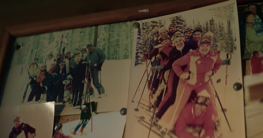 Pictures on a wall of several groups of people in skiing gear