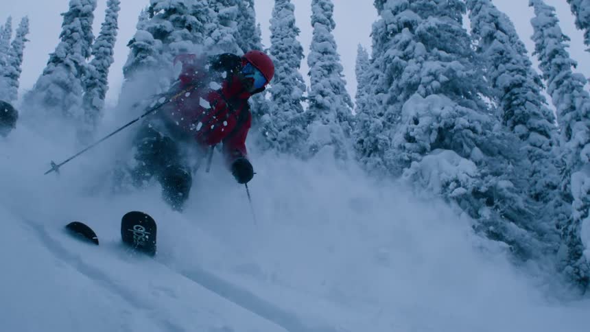 Man skiing on snow wearing red coat