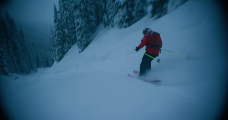 Person skiing on snow wearing red coat