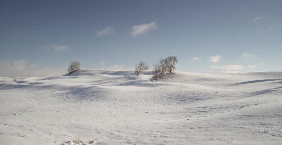 Snow covered hills sit motionless on a sunny day