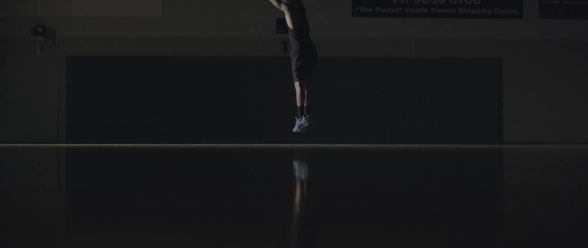 A man jumps and shoots a basketball