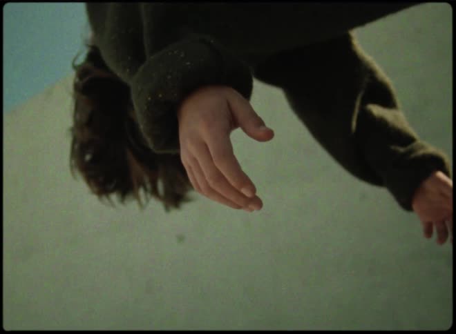 Young person floats near a wall with arms hanging down