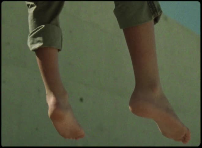 A persons bare feet are hanging down