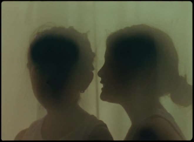 Silhouettes of two girls whispering