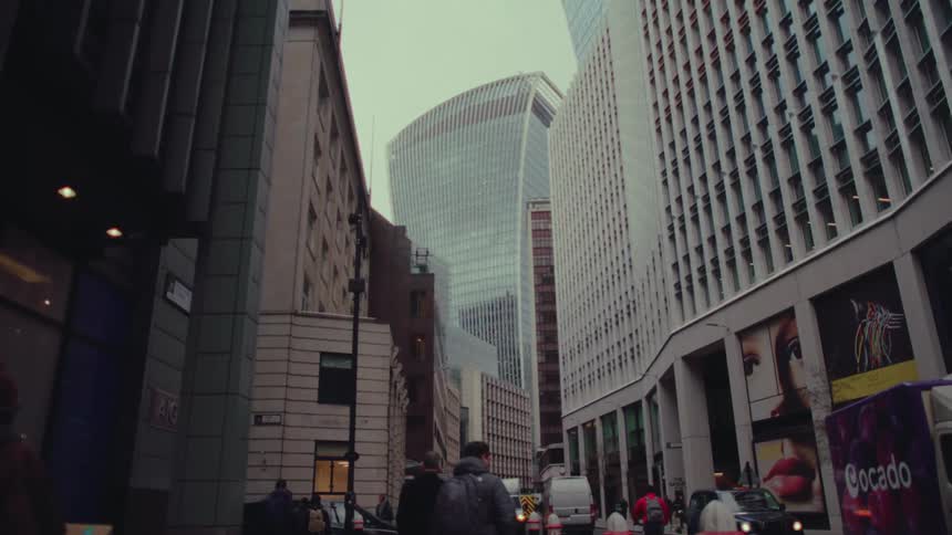 Tall buildings line a street in a city during the day