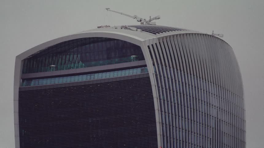 Workers with a crane are working on top of the tall building