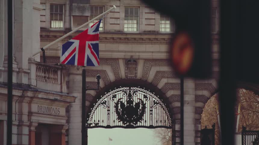 A flag hanging on a building wall close to a gate
