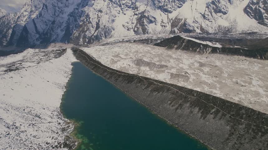 Aerial view of lake and high snowy mountain ridge