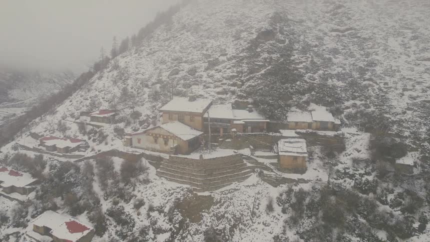 Aerial view of small village on snowy mountain slope