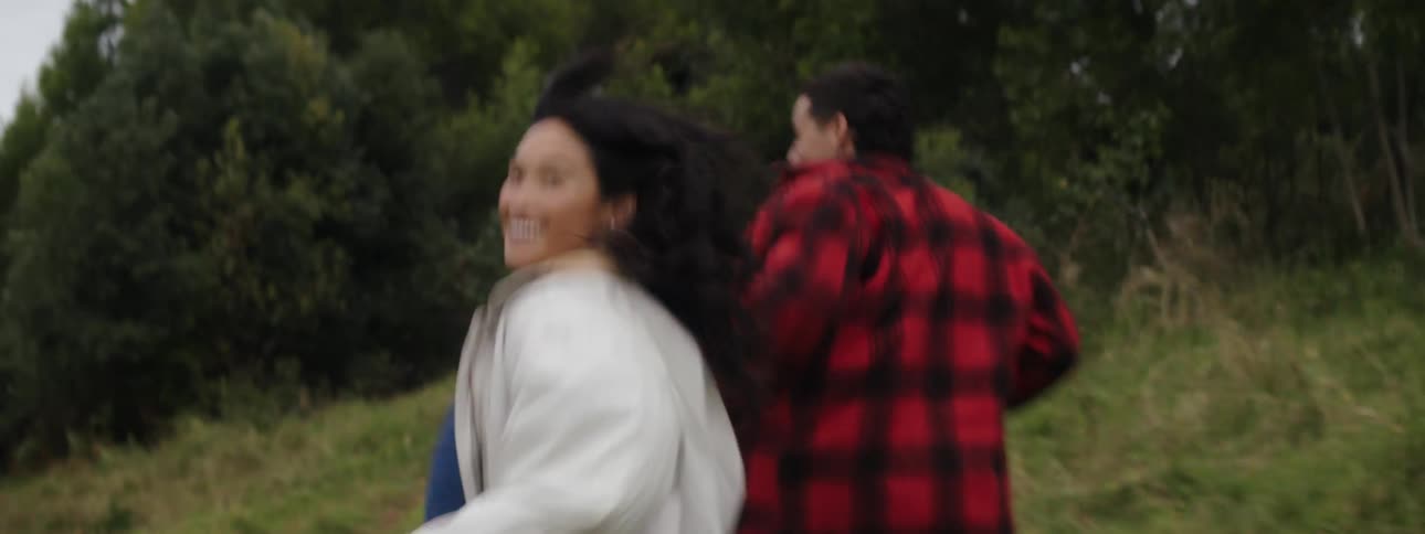 Group of happy friends running on a path through a clearing near the woods