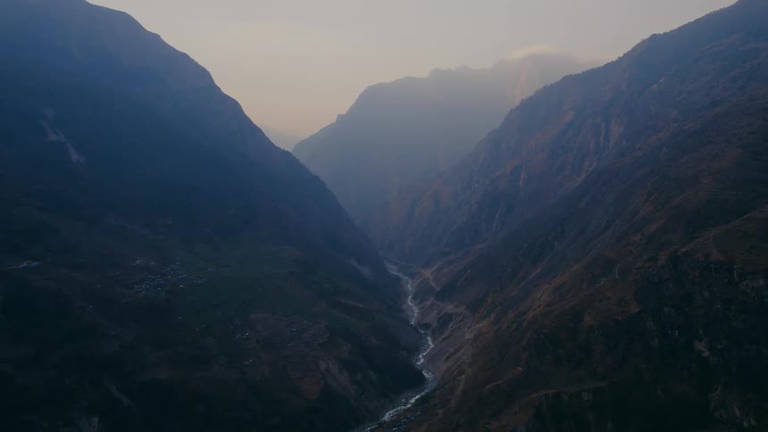 Stream at mountains base with distant fog in view