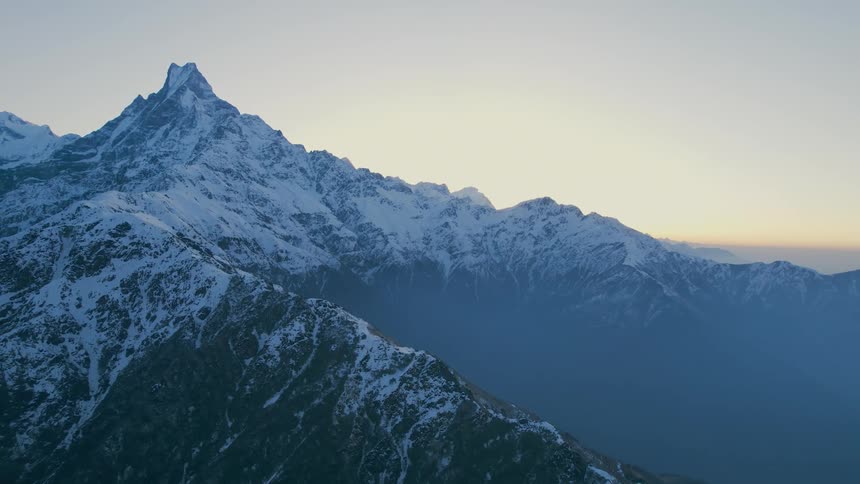 Aerial view of snowy mountain ridge at dusk