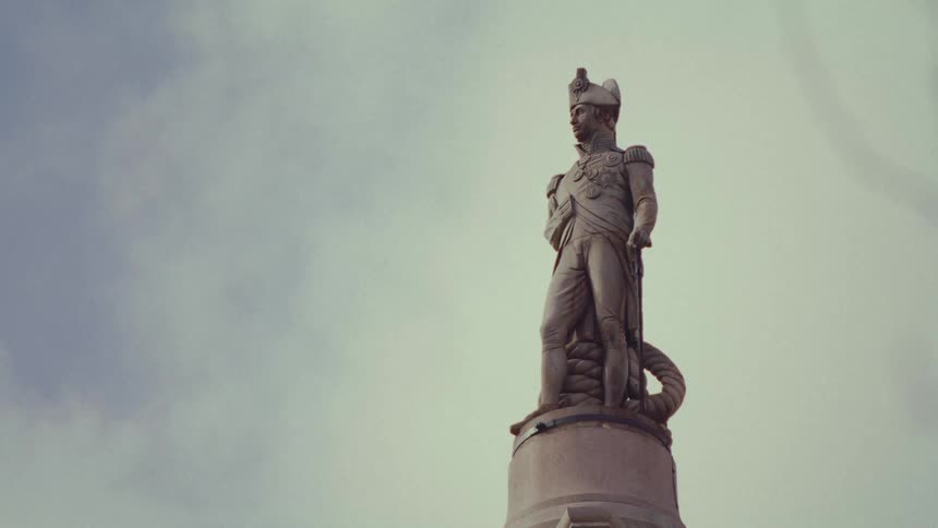 A statue of a military leader stands on a pedestal under a cloudy sky
