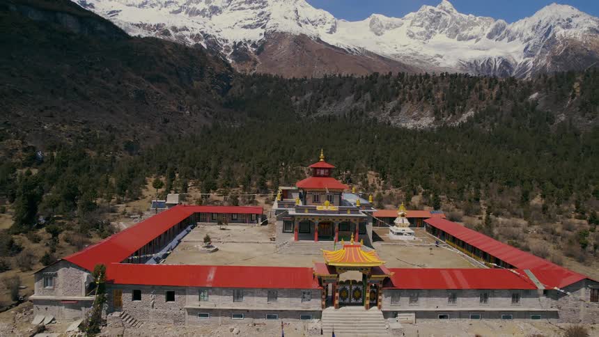 An ornate temple is situated within a valley lined by mountains