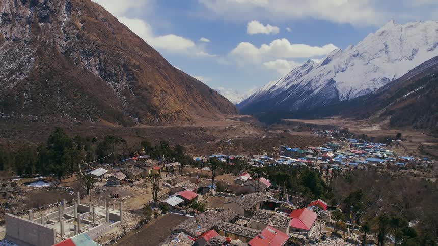 A small village is located at the base of a towering mountain range