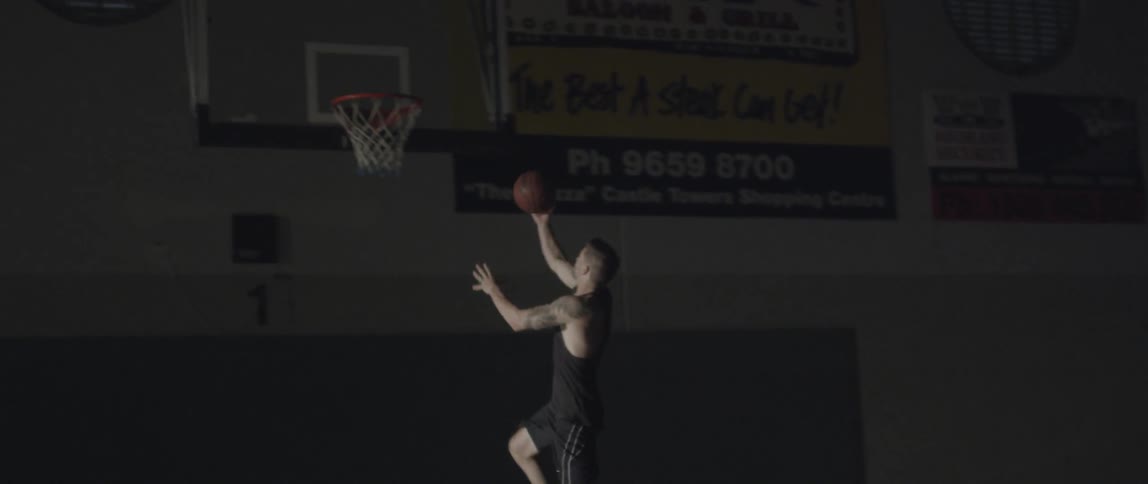 A man drives the basketball past a player and shoots