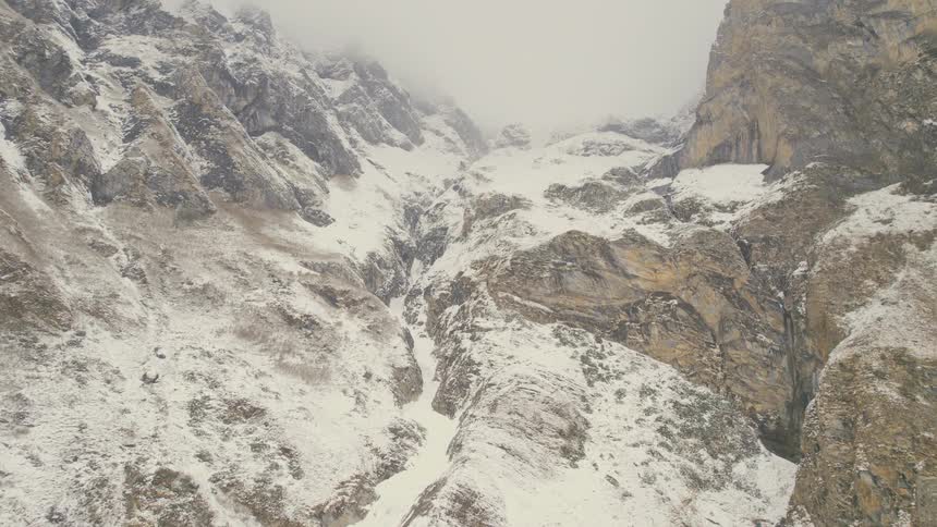 An aerial view of an icy mountain with snow on it