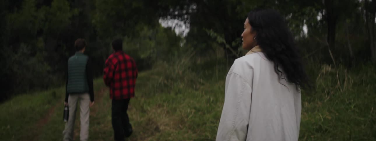 A woman turns and looks at her surroundings while hiking with others