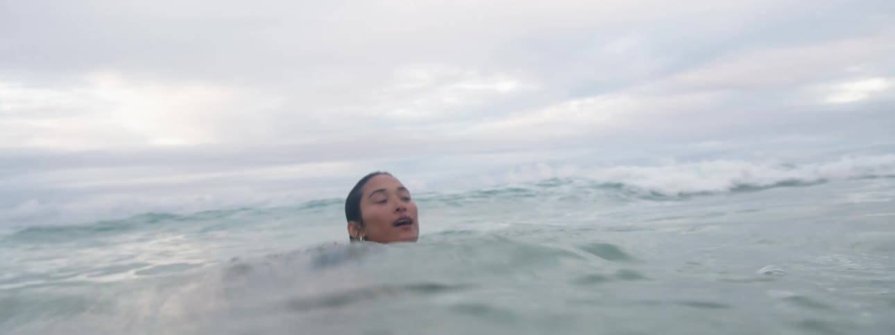 A woman looks around while swimming in the ocean