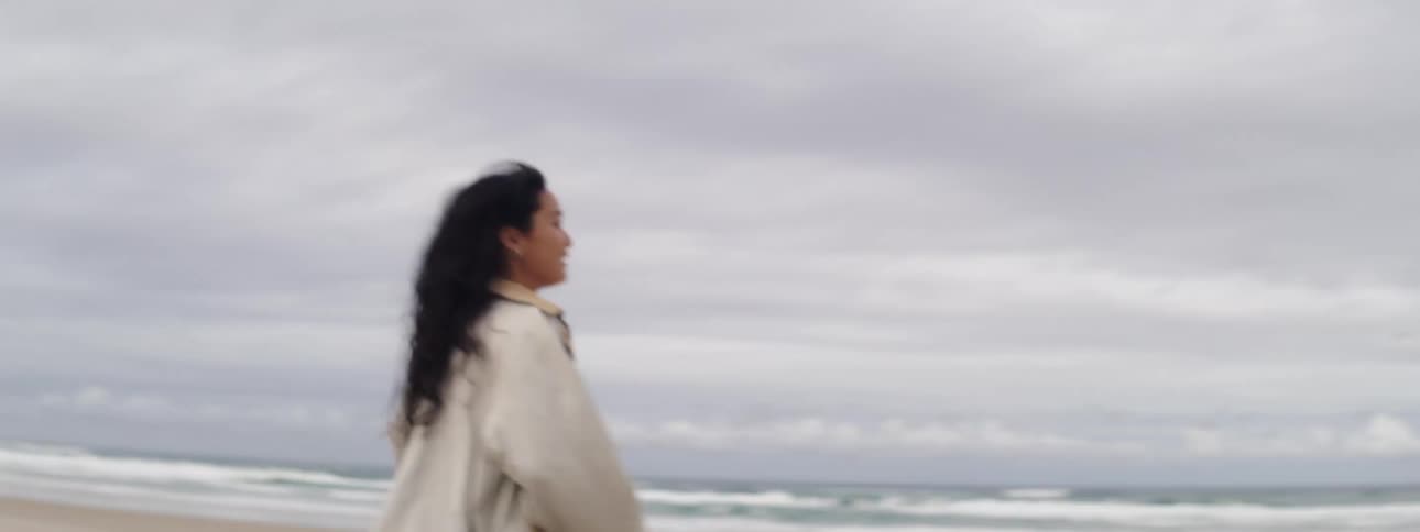 A woman running happily across a beach