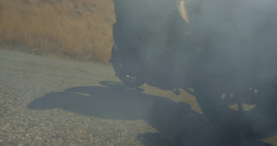 Motorcycle tires drift and smoke into a turn