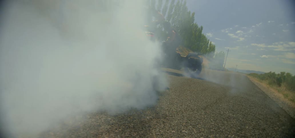 Motorcyclists doing burnouts on a gravel road