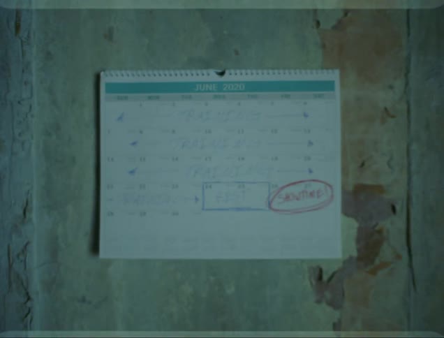 A calendar covered in writing pinned to a dilapidated wall