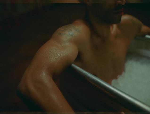 A man sits in a metal tub full of ice