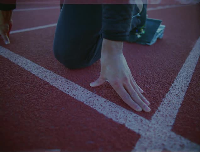 Man getting ready to run on an athletic track