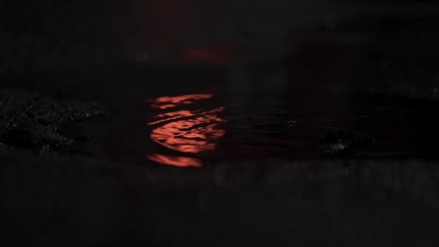 Water drops in a puddle at night