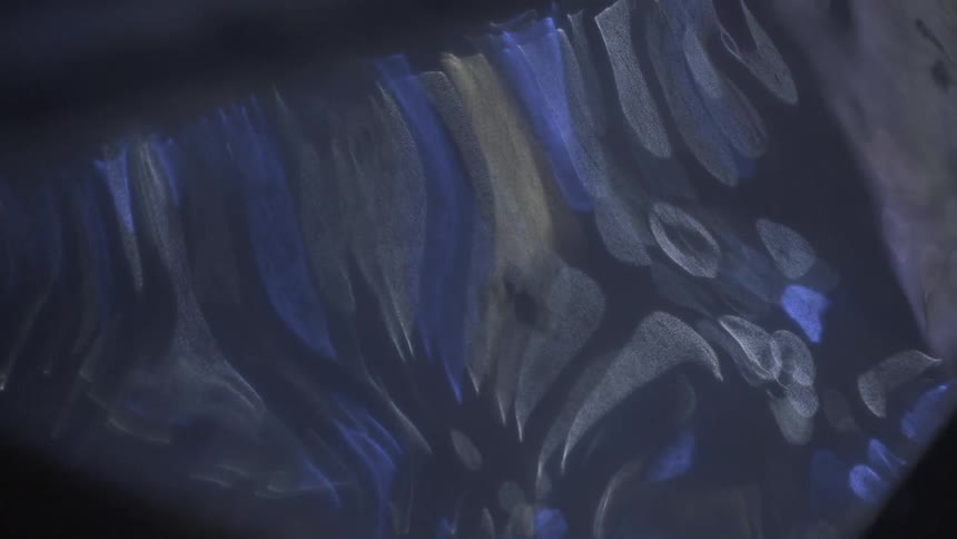 Colors swirl in a reflection in the dark