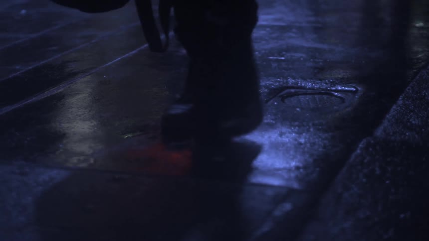People are walking over a sidewalk at night
