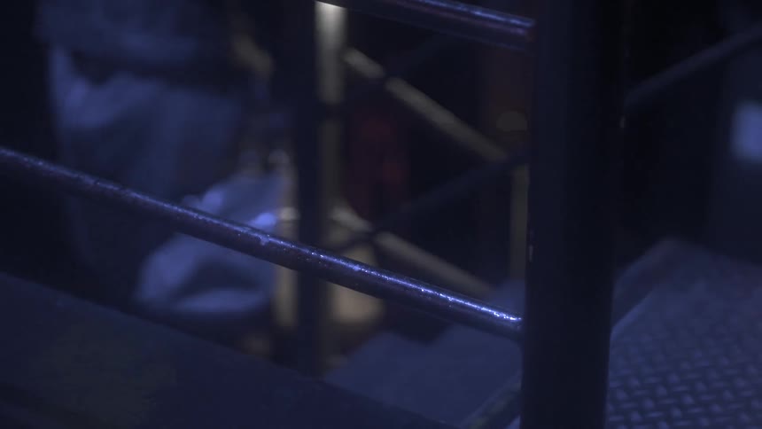A person walks down stairs in the dark