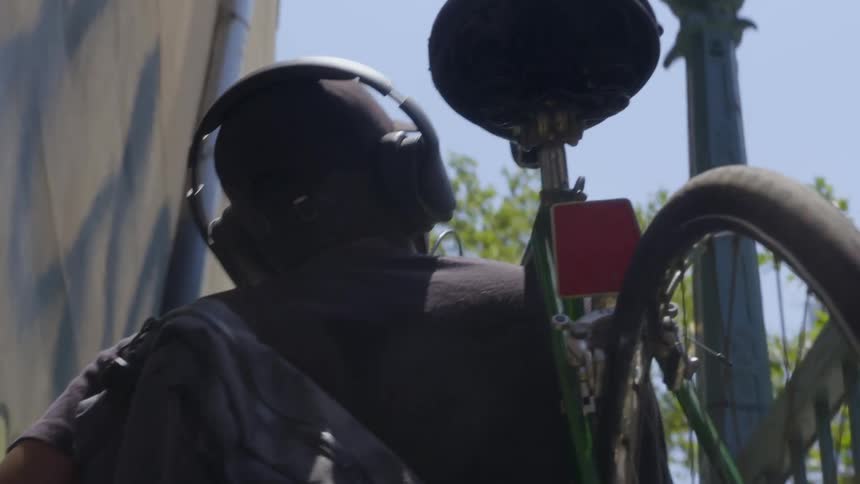 A person carries his bicycle up the stairs