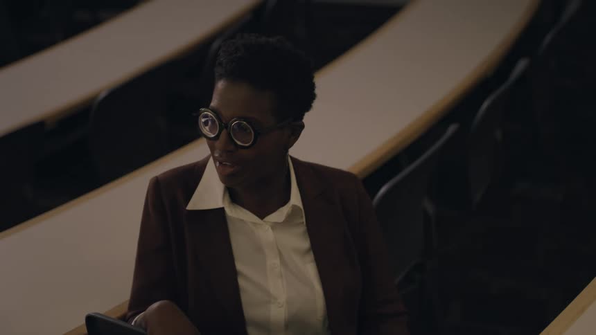 Black person on formal wear and glasses talking and laughing indoors