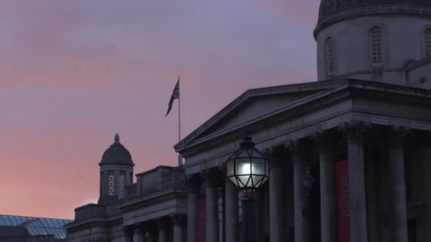 An american flag stands outside a pillared building