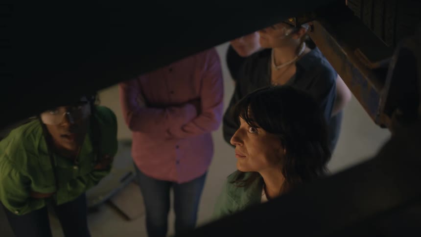 A group of women in an underground tunnel talking to each other while looking up