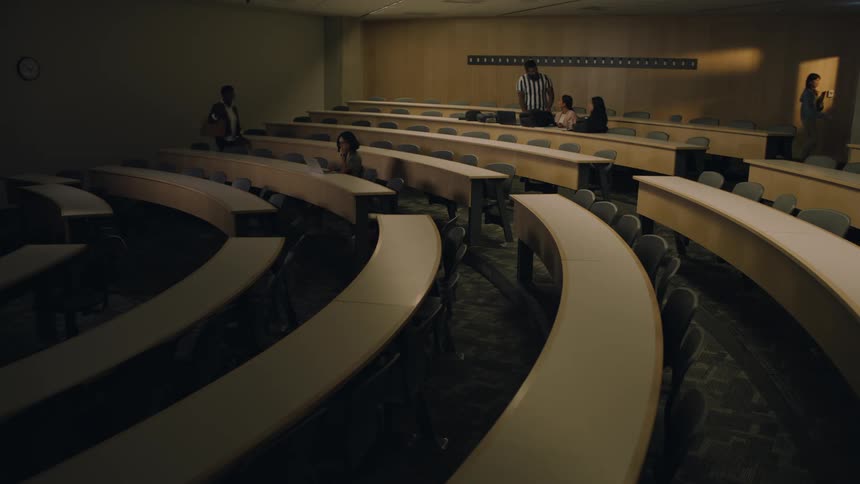 Group of students talking to each other on a university lecture hall