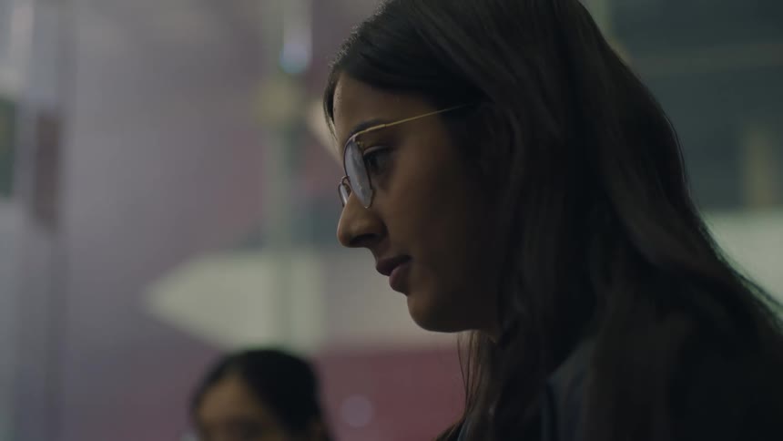 Face of a woman wearing glasses looking out of frame