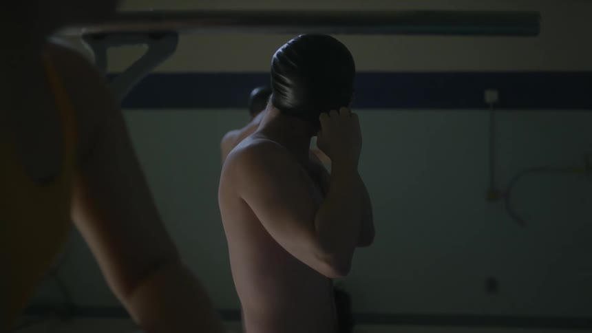 Male swimmer wears swimming cap