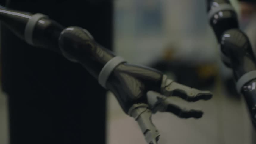 A robot in a lab moves its arms while people watch
