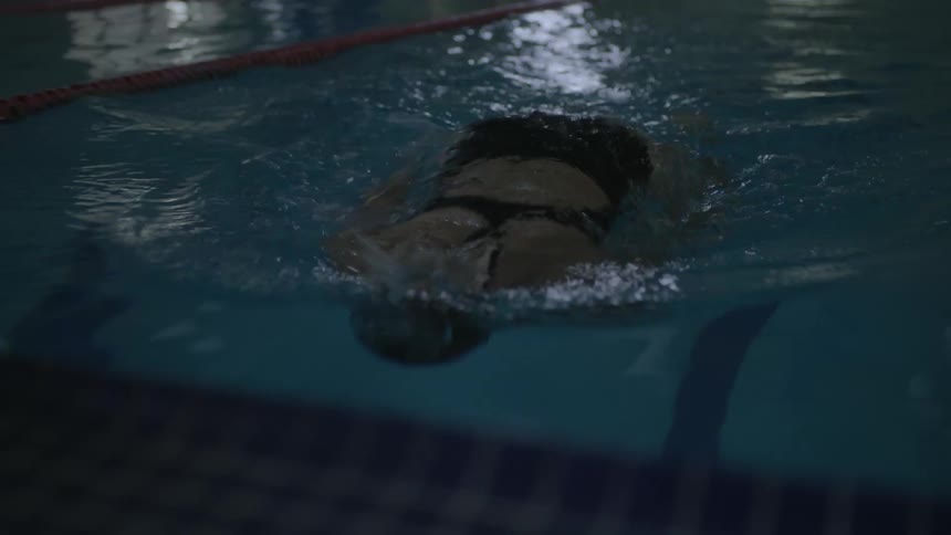 A woman swims in a pool lane using the front crawl