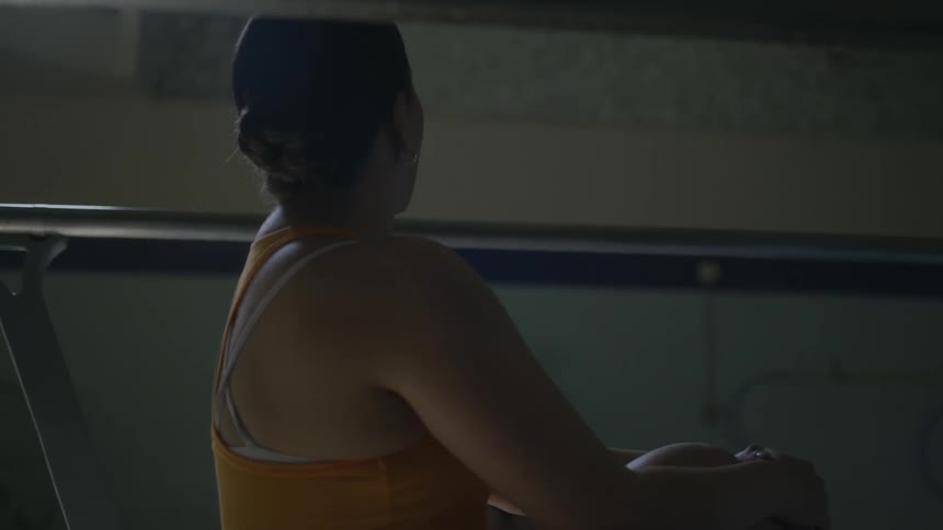 A female coach communicates with another woman entering a swimming pool