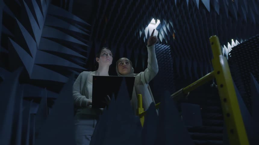 Teacher explains a student the acoustic wedge foam on a studio